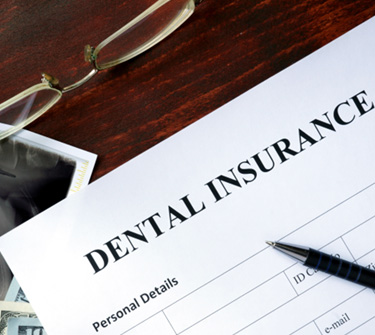 Top of dental insurance form with pen and glasses