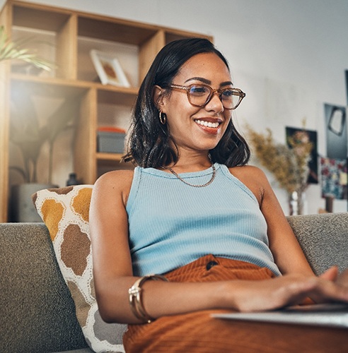 Woman smiling while working on laptop at home