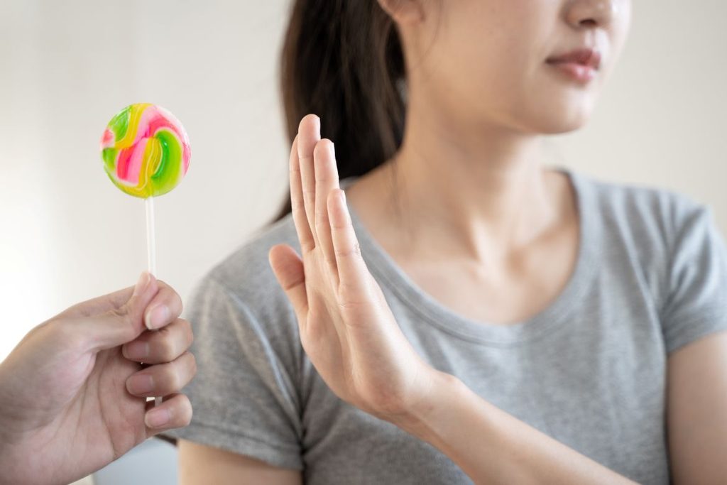 A woman refusing a lollipop